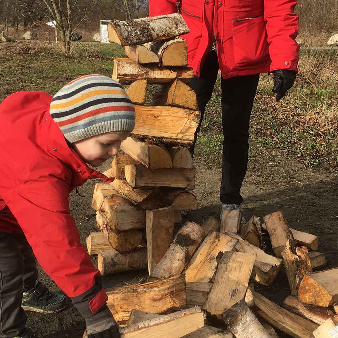 olympiad Barn sträcker sig efter ett vedträ dör att bygga ett högt torn.