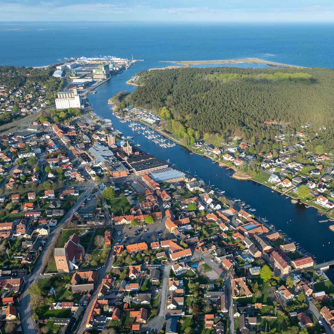 Flygbild över Helgeåns utlopp i Åhus med hamnen och bebyggelse