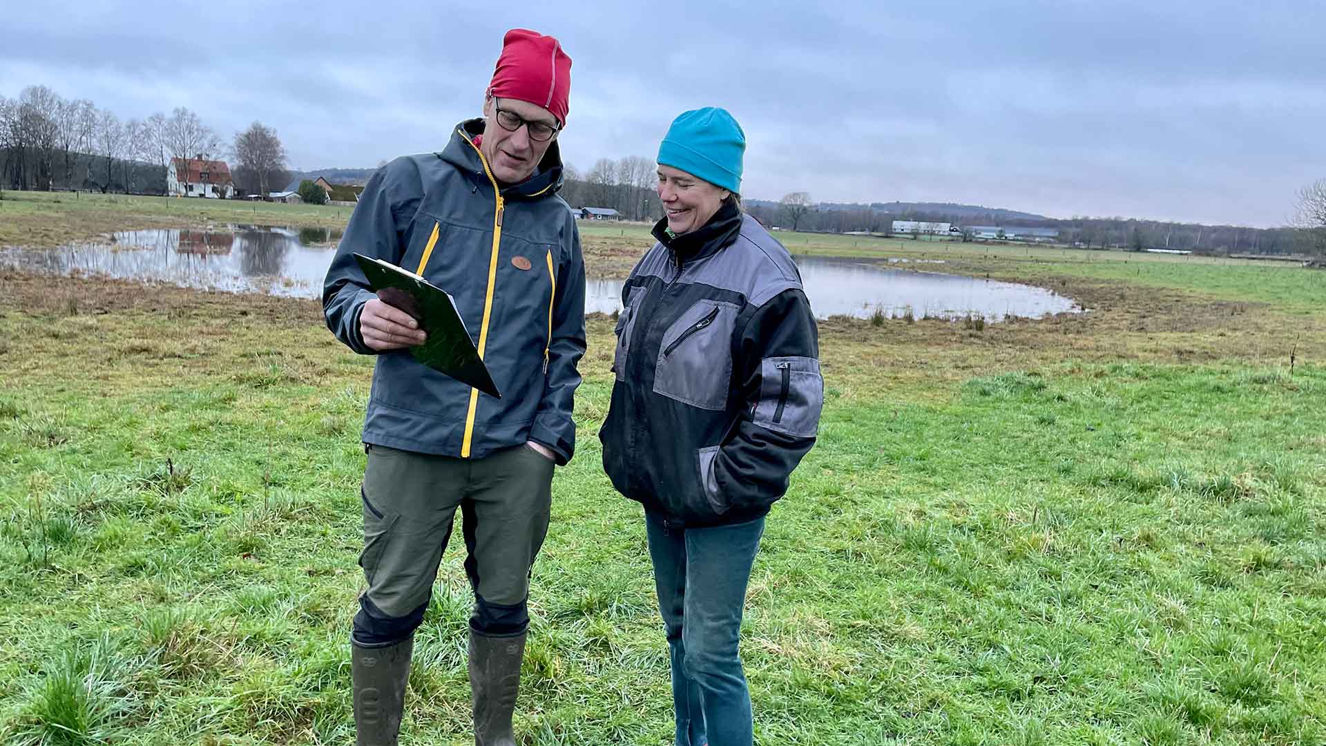 Två personer stpr vid en våtmark och samtalar. Foto Åsa Pearce