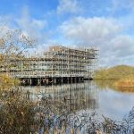 Naturum sett från naturumsjön. Hela fasade är klädd i byggställning.