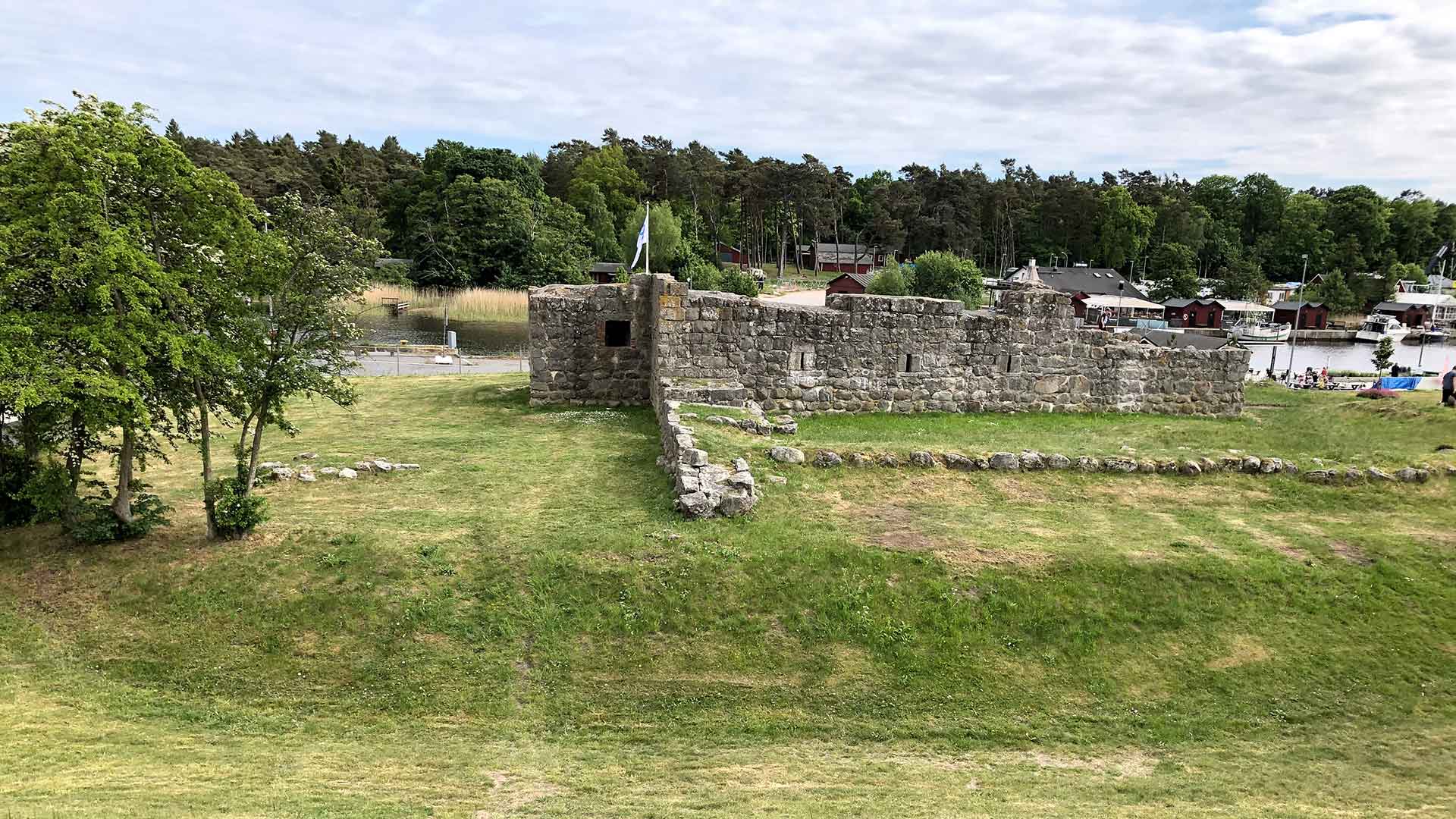 Ruinen Aosehus har grund och väggar. Bortom ruinen skymtar Helgå å. Foto Åsa Pearce