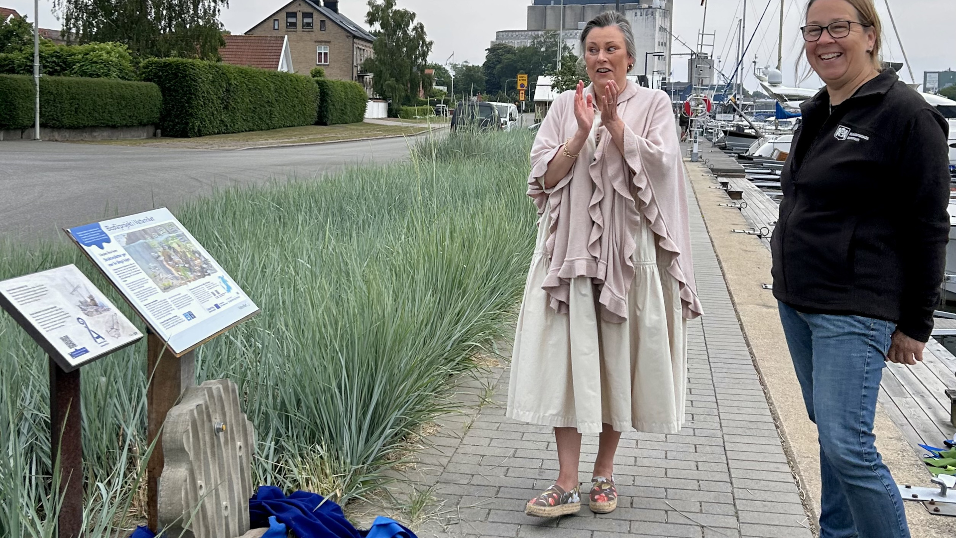 Kommunstyrelsens ordförande Camilla Palm och kommunekolog Ulrika Hedlund står vid infoskylt och strukturplatta när lärplatsen invigs. Foto: Åsa Pearce